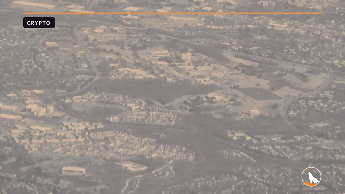 An aerial view of the NIST campus in Gaithersburg, graded navy and orange, with the wolf mark.