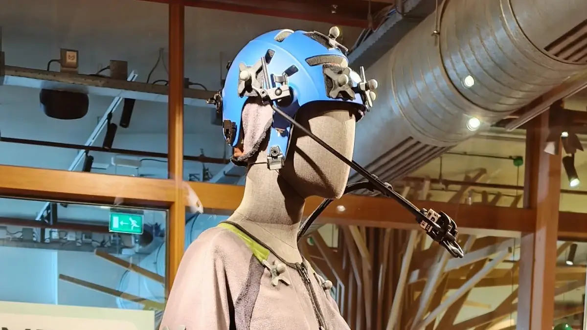A mannequin in a motion capture suit and a marker helmet with a head-mounted face camera, on display