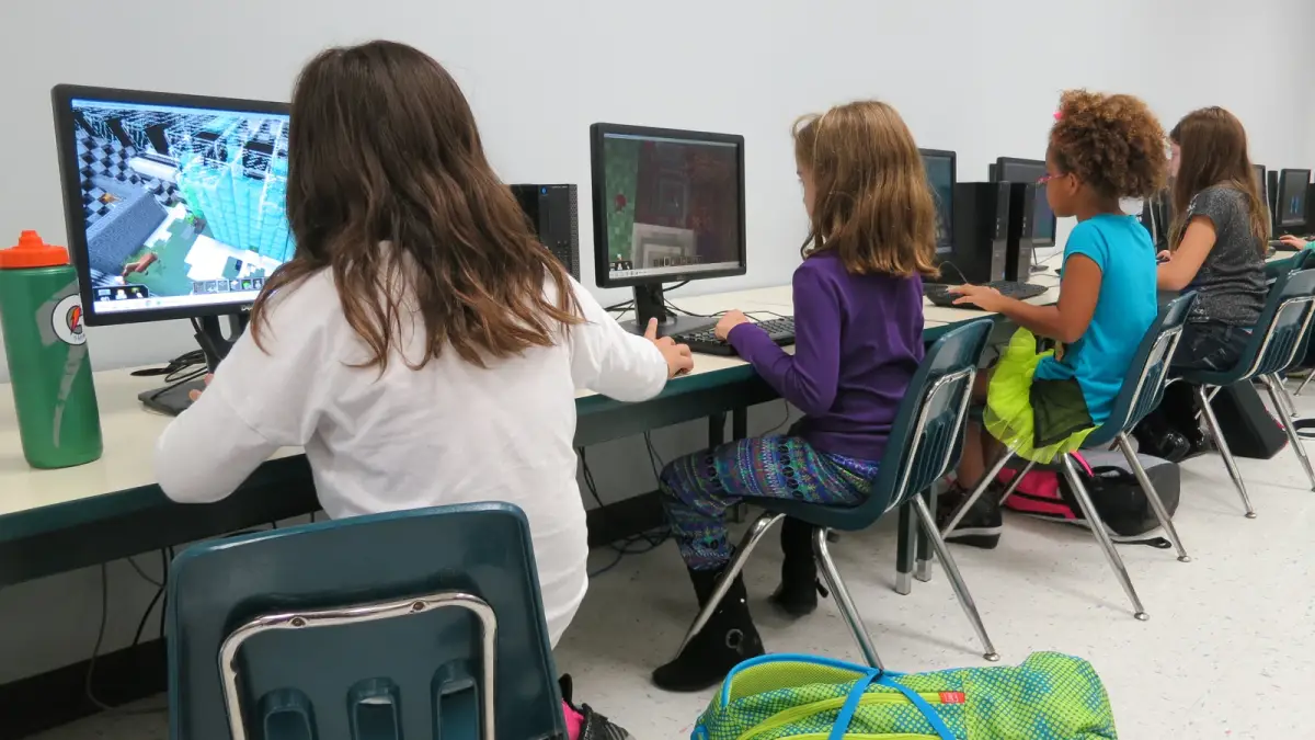 Students playing Minecraft on computers in a school computer lab.