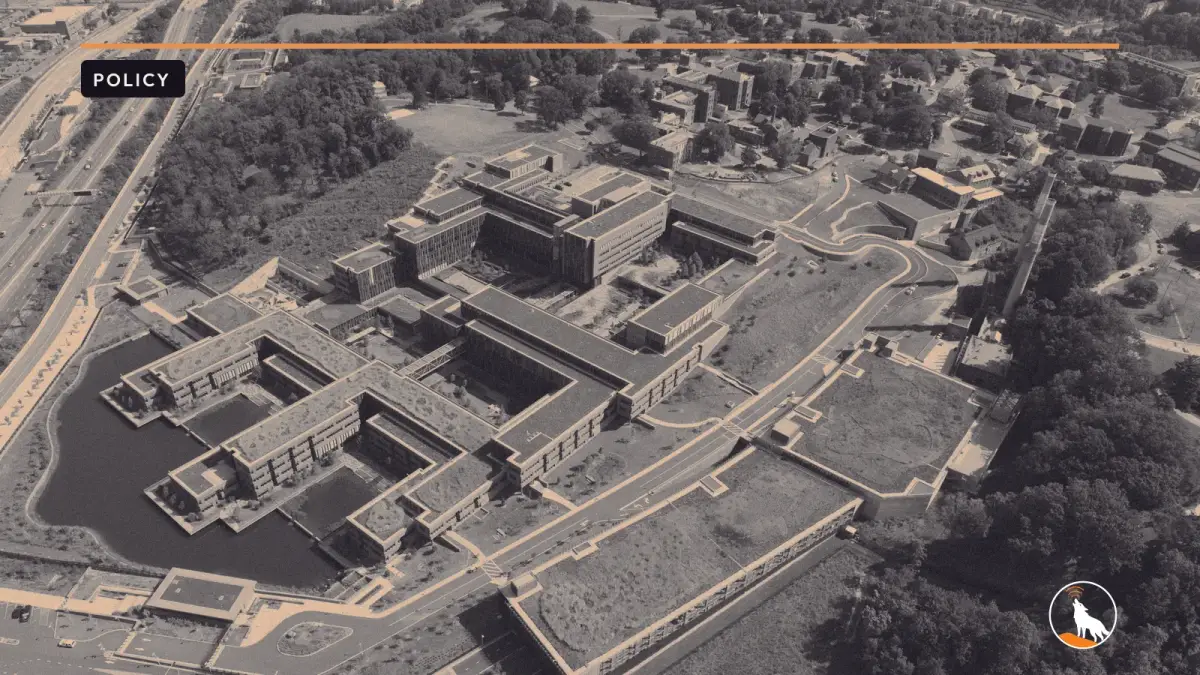 Aerial view of the Douglas A. Munro Coast Guard Headquarters Building on the St. Elizabeths campus in Washington, graded navy and orange, with the wolf mark.