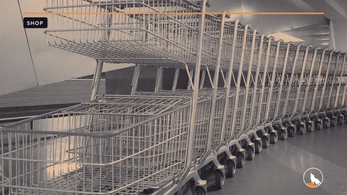 A long curving row of empty, nested wire shopping carts with orange handles on a polished tile floor.