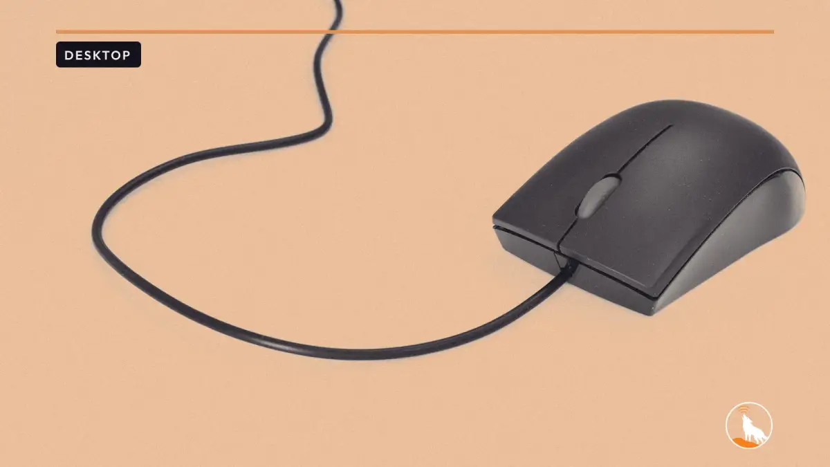 A black wired computer mouse with a red scroll wheel on a plain white surface, its cable curving away across the frame.